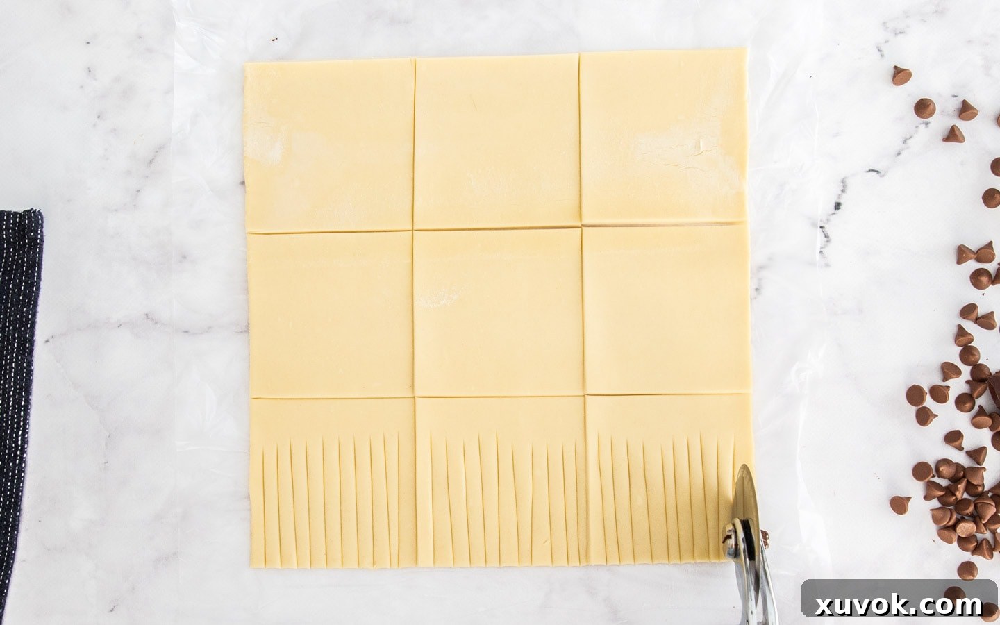 Showing how to cut the strands of puff pastry.
