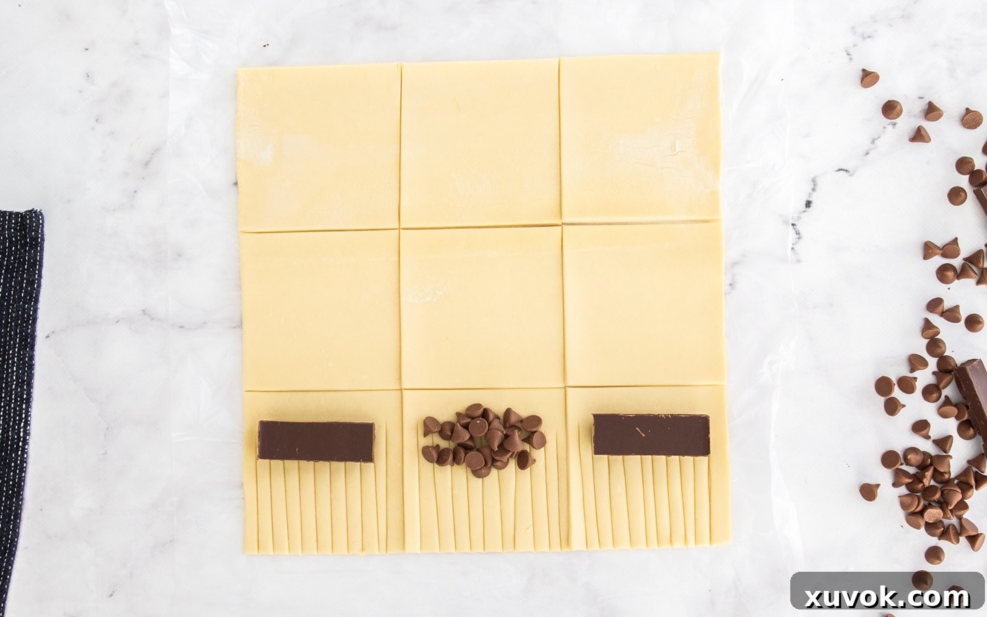 Squares of puff pastry with pieces of chocolate on top.