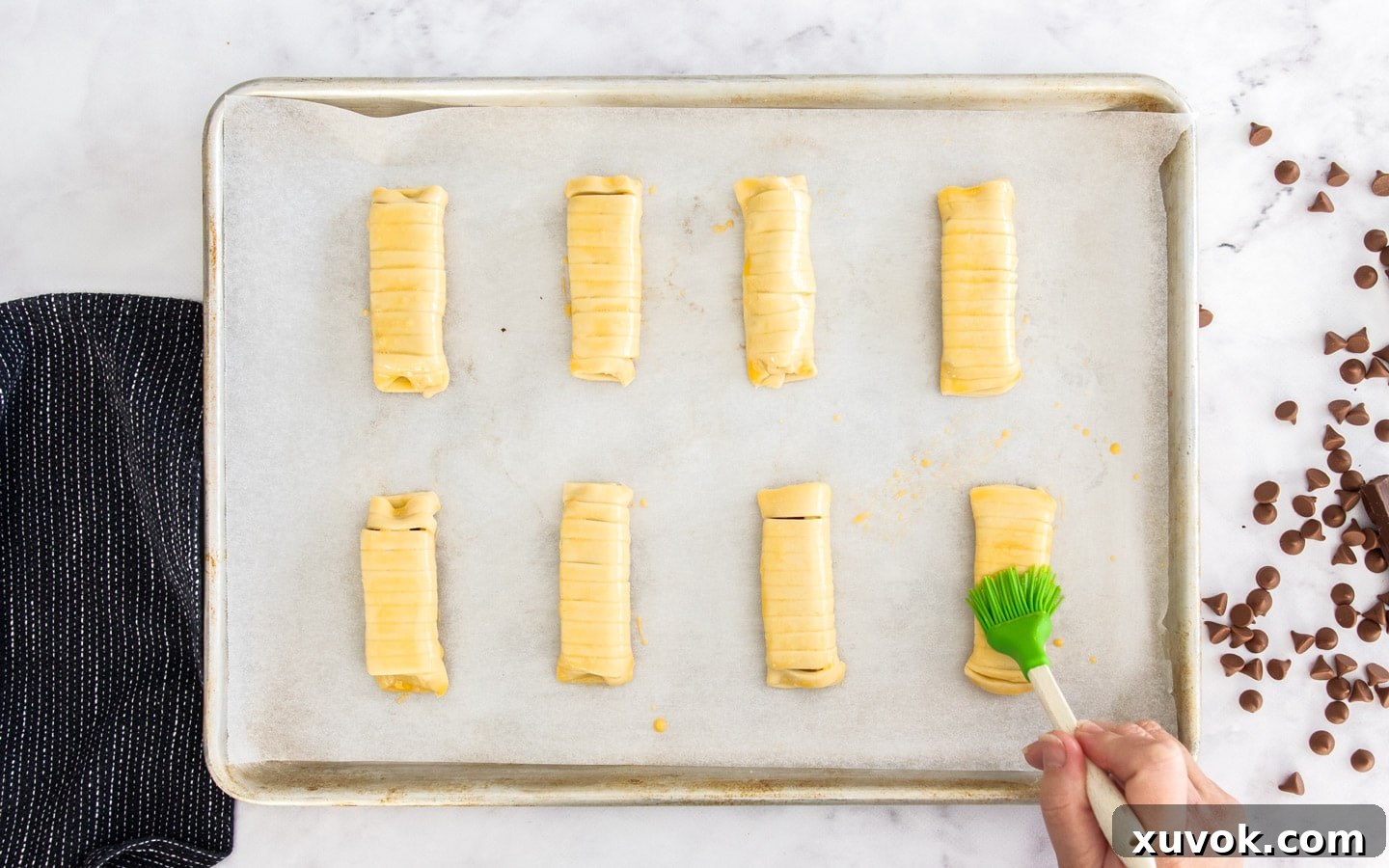 Brushing the puff pastry with egg wash.