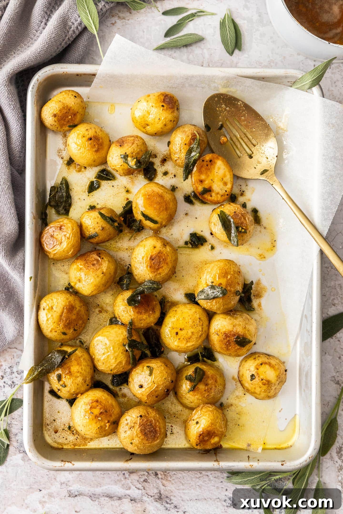 Top down view of roasted mini potatoes on a bakign sheet.