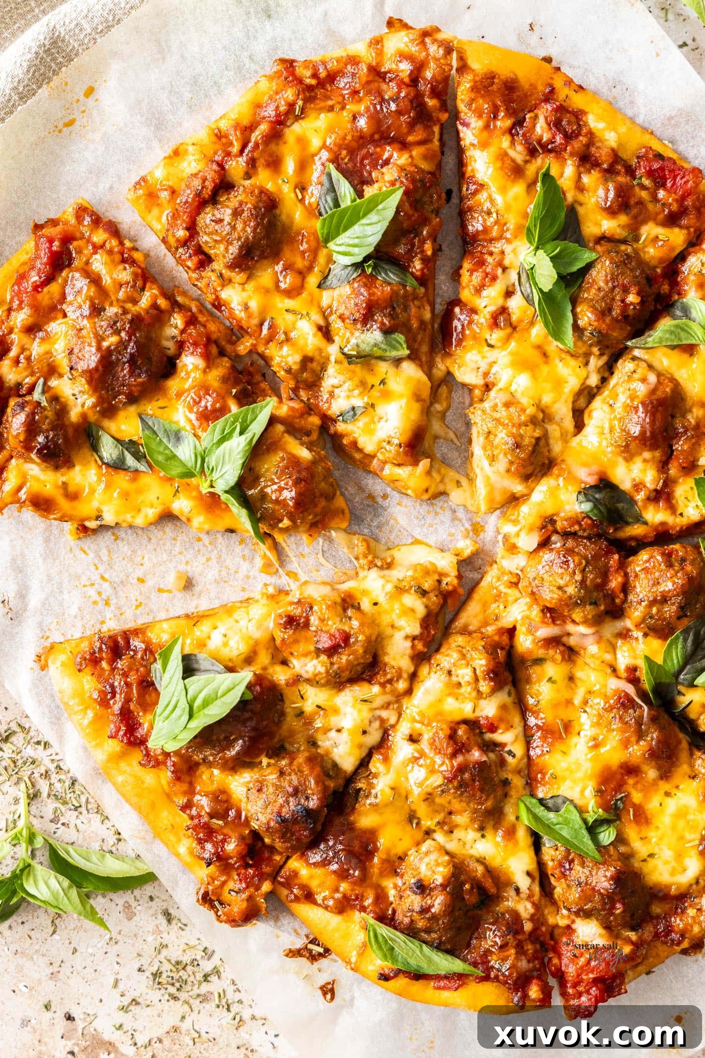 Meatball pizza cut into 8 slices.