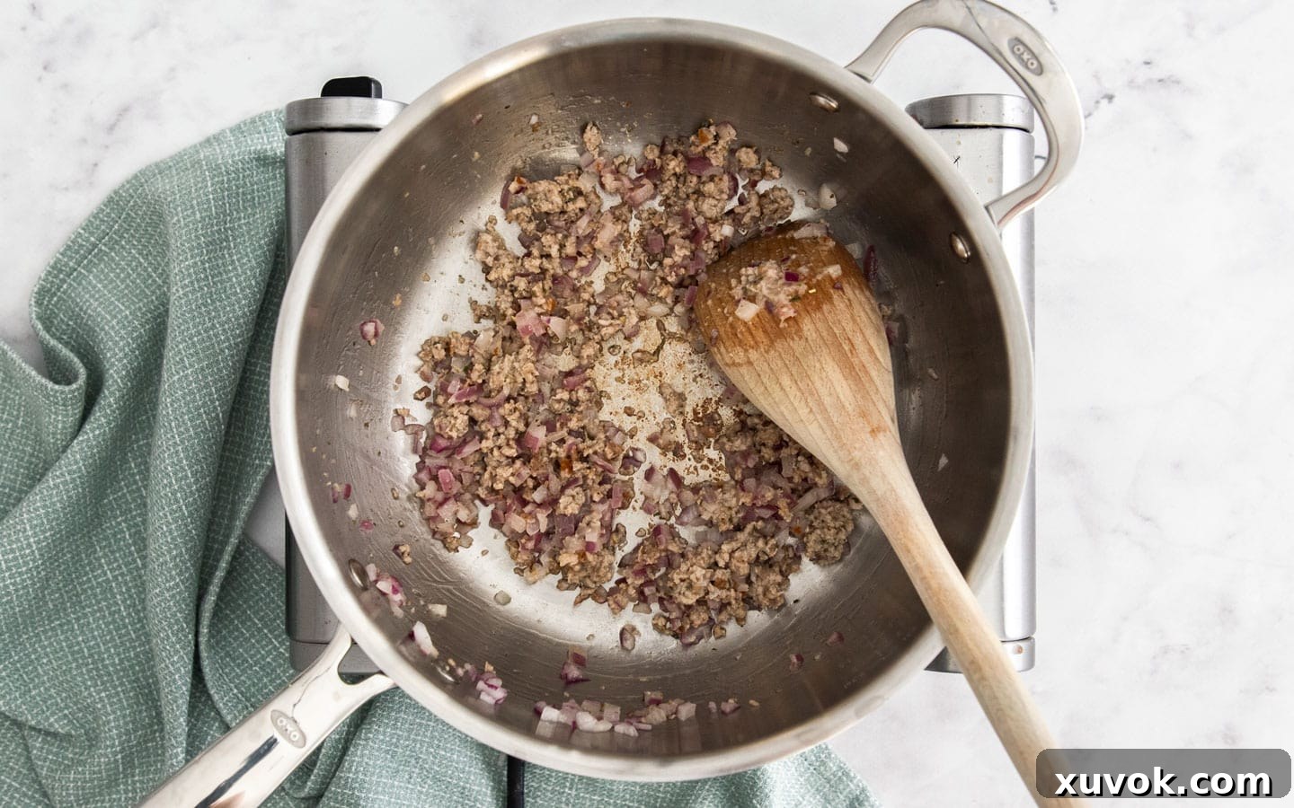 Cooking onion and some meat in a pan.