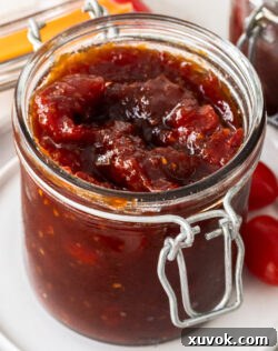 Closeup of a glass jar filled with tomato chilli jam.
