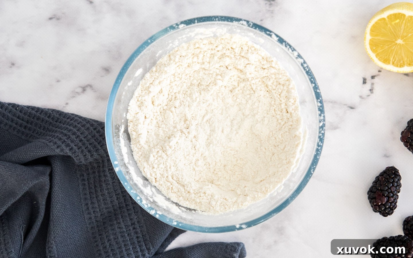 A bowl containing the whisked dry ingredients for the lemon blackberry cake, ready for mixing.