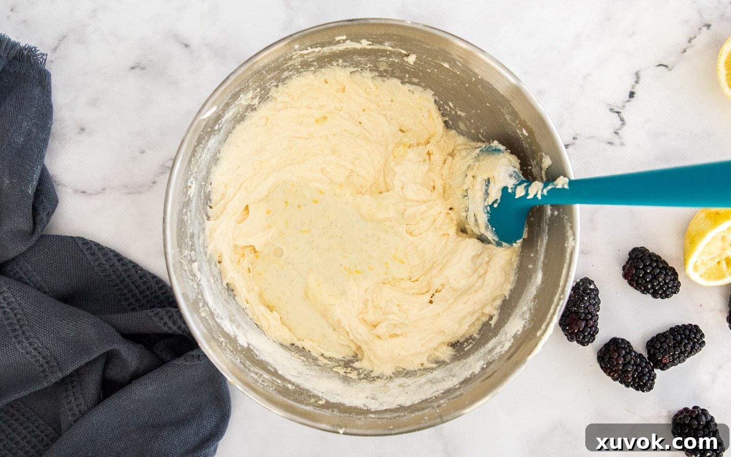 The wet ingredients (yogurt mixture) being added to the cake batter in an alternating sequence.