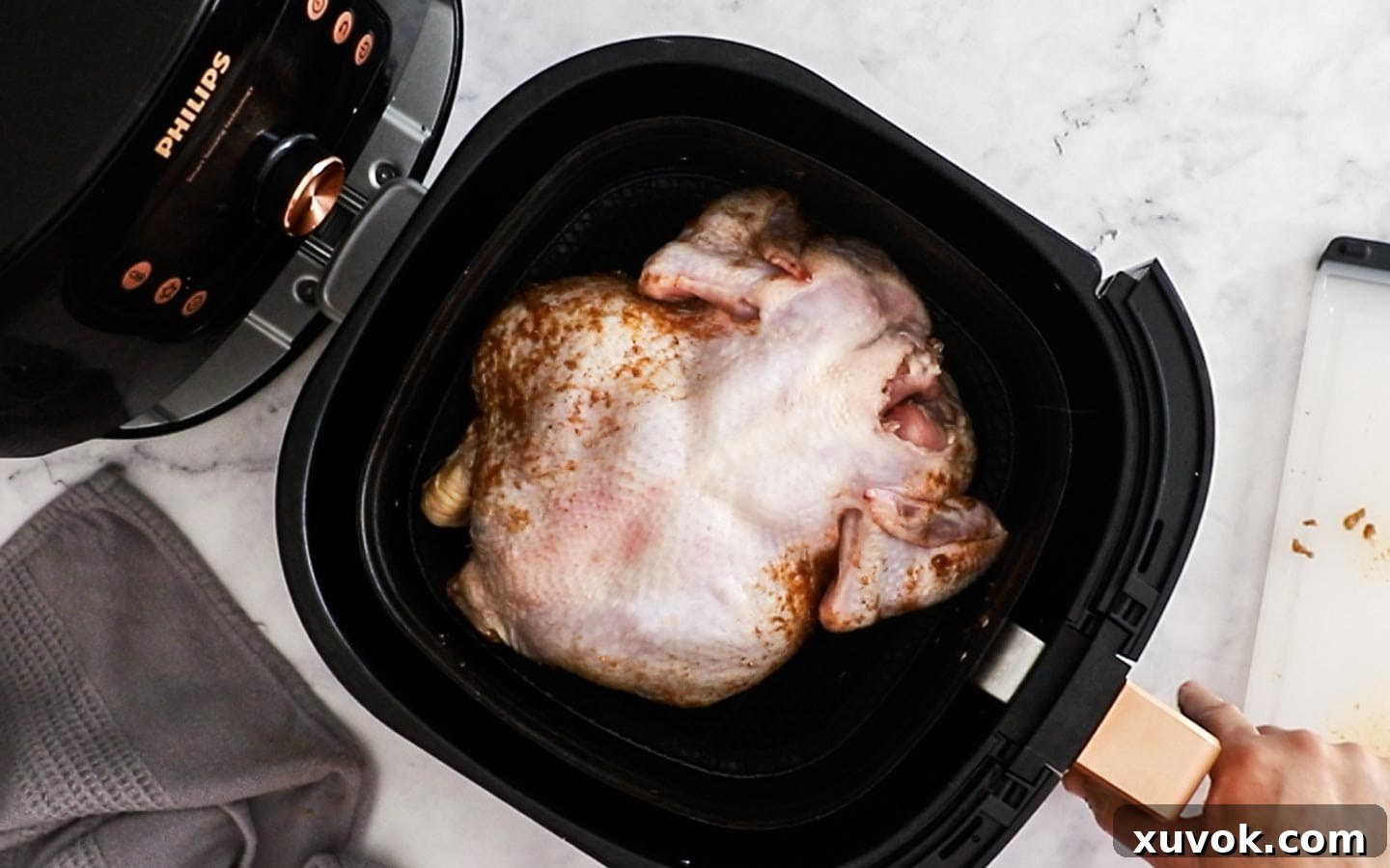 Putting the whole chicken into the roast chicken.