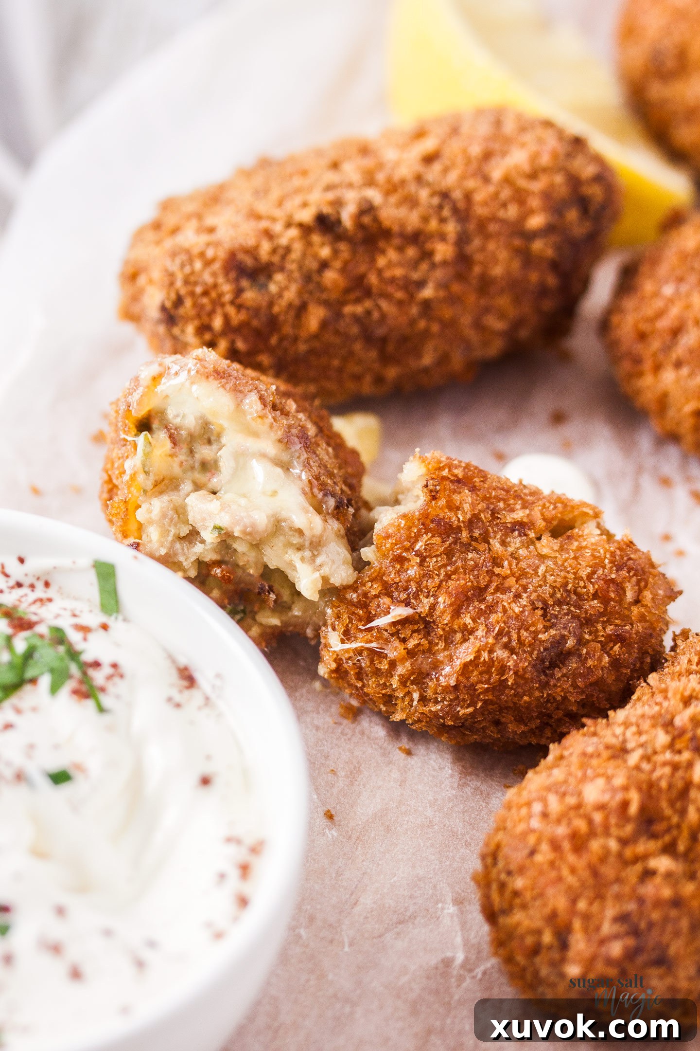 A pork croquette broken in half, revealing its tender, cheesy center.