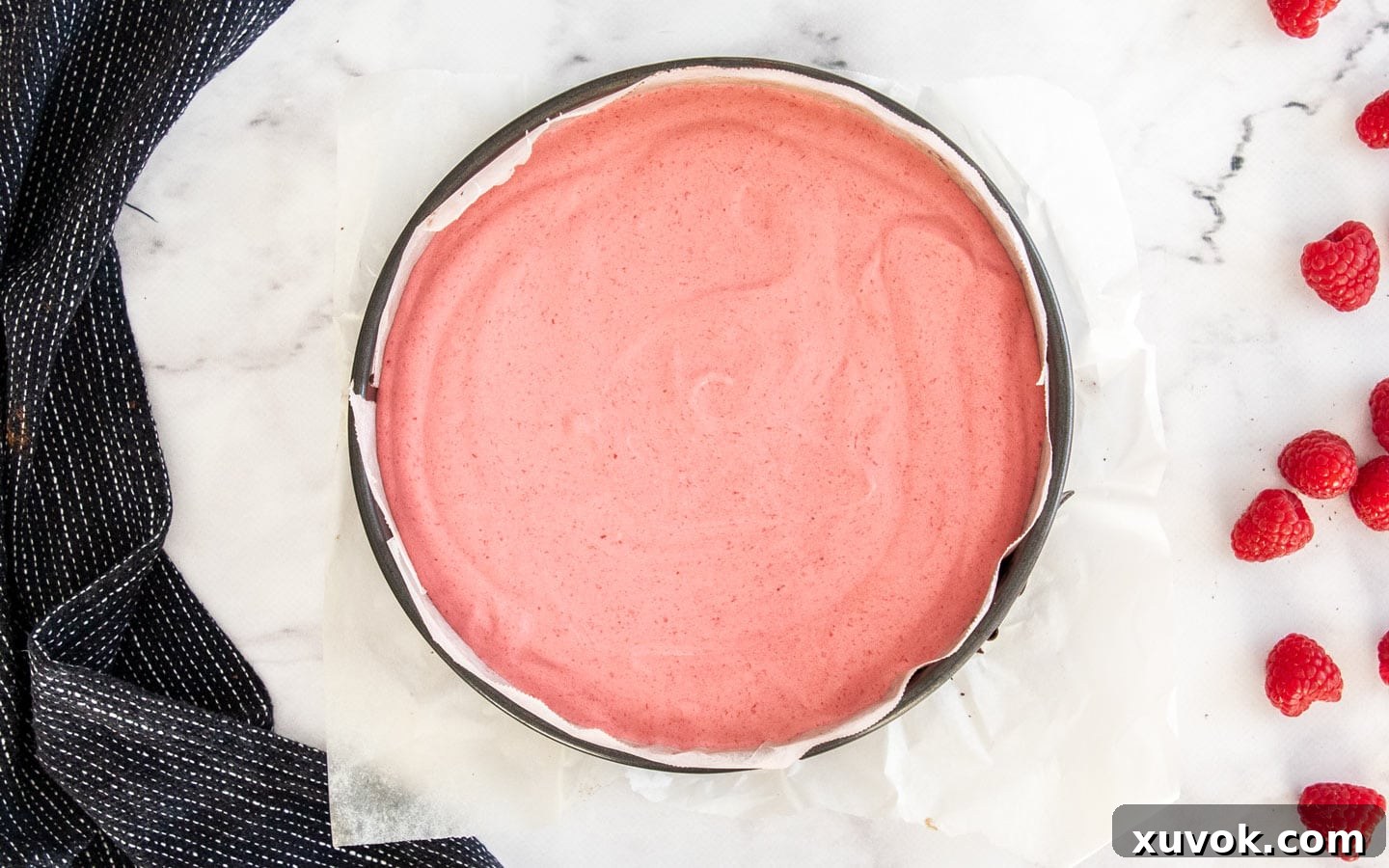 The finished raspberry mousse poured over the brownie base in a springform pan.