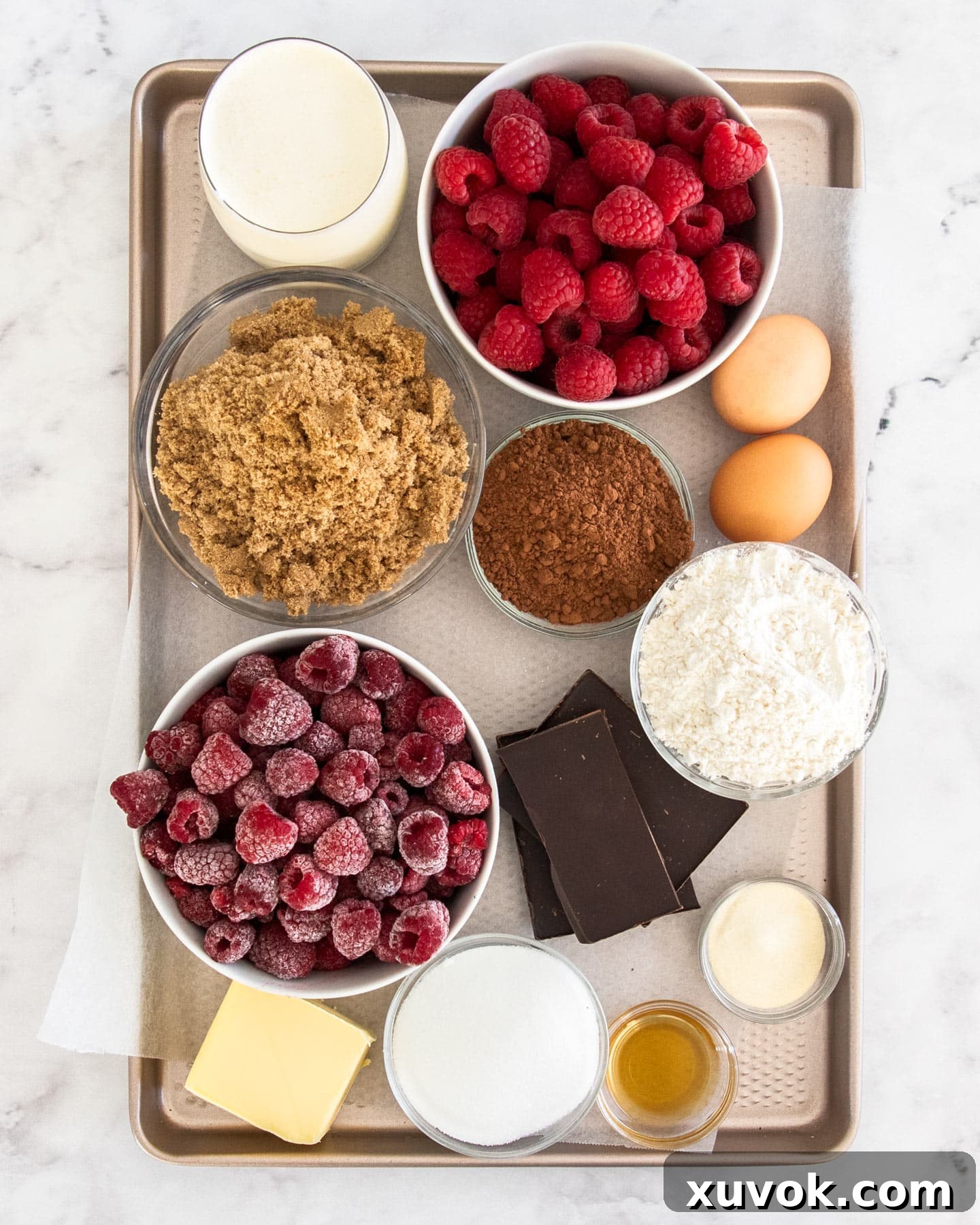 Ingredients for chocolate raspberry mousse cake laid out on a baking tray.