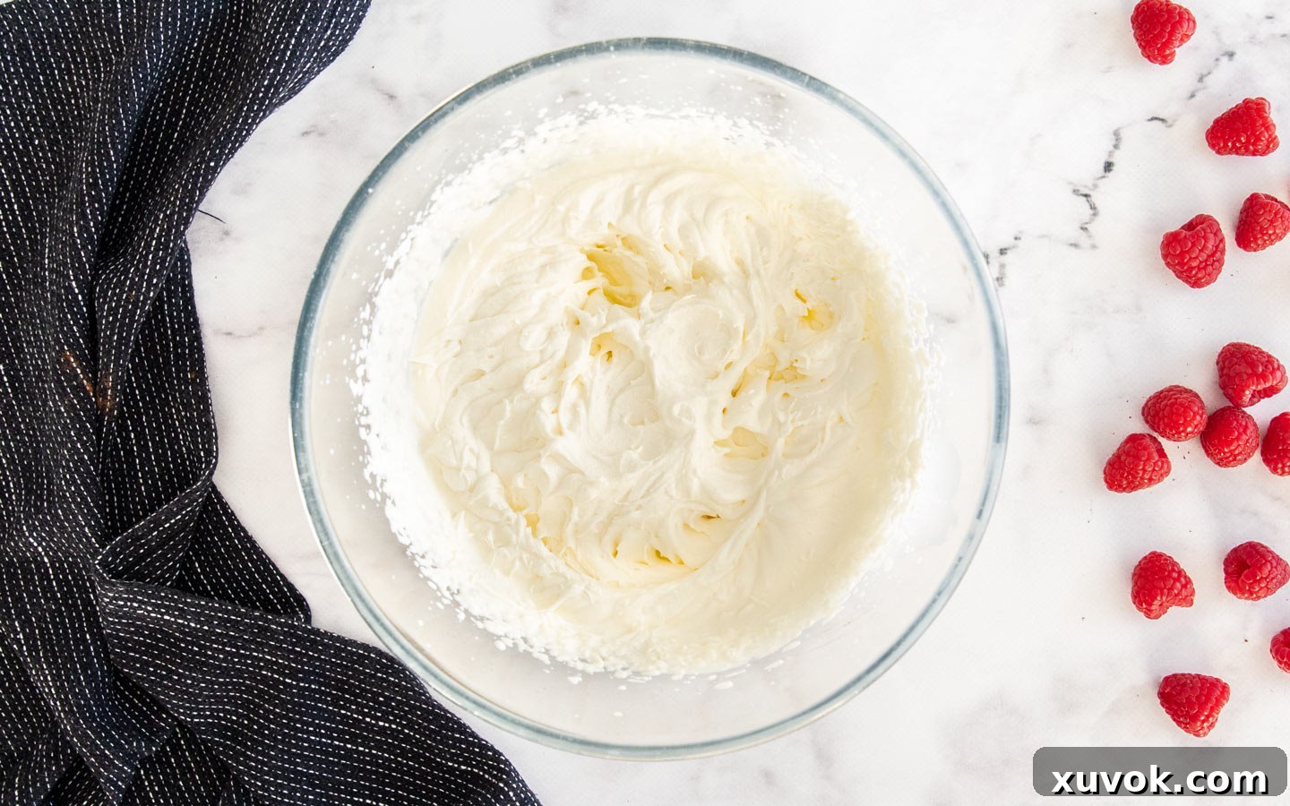 Whipping cream beaten to stiff peaks in a large bowl.