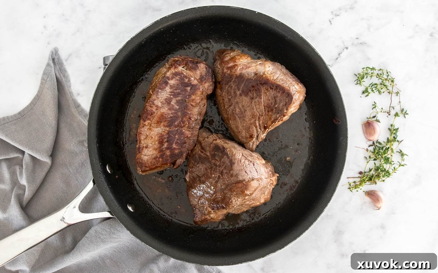 Chunks of beef browning in a hot pan.