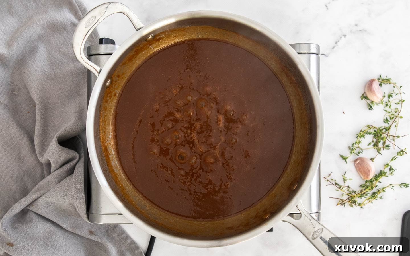 The thickened gravy simmering gently in a pan, ready for the beef.