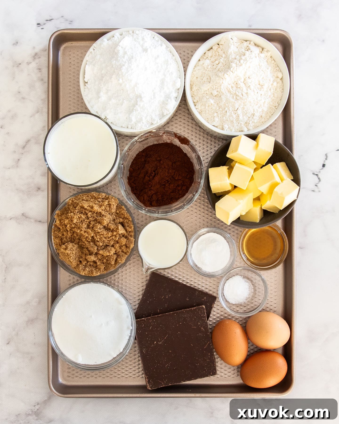 A collection of fresh ingredients laid out, ready for making chocolate mini cakes.