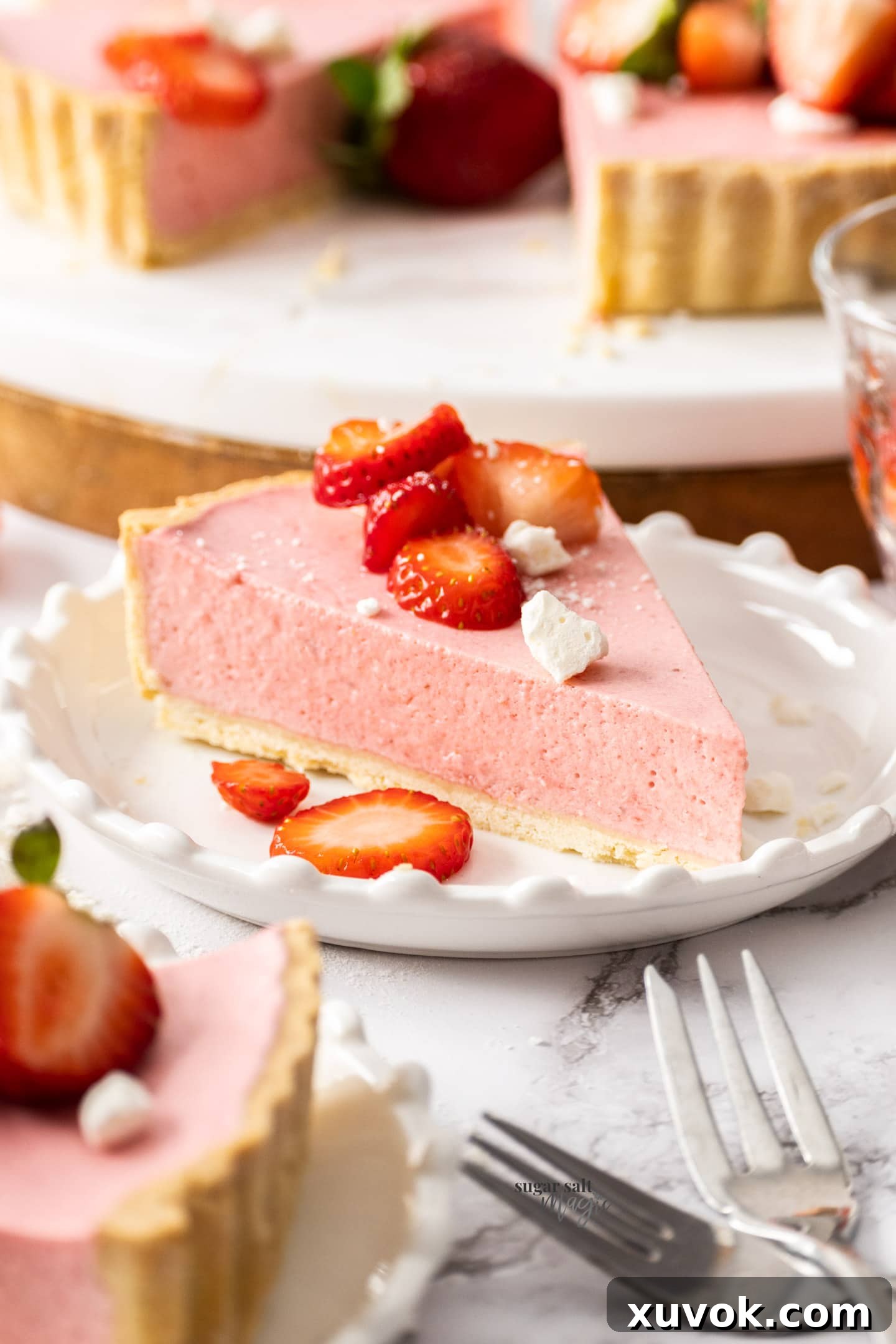 A slice of strawberry mousse tart on a small dessert plate, garnished with fresh berries.