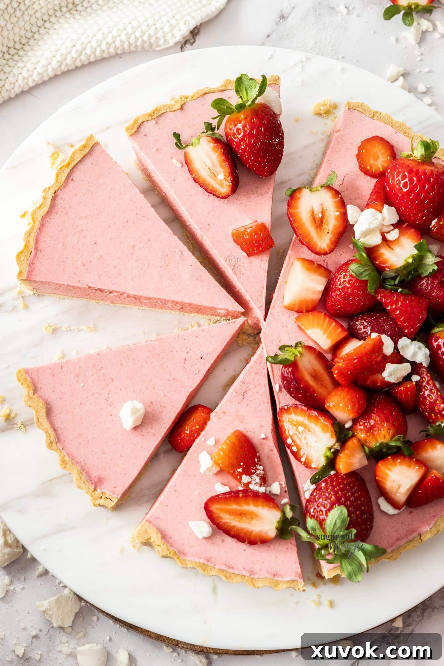 Top down view of the strawberry mousse tart cut into slices, garnished.