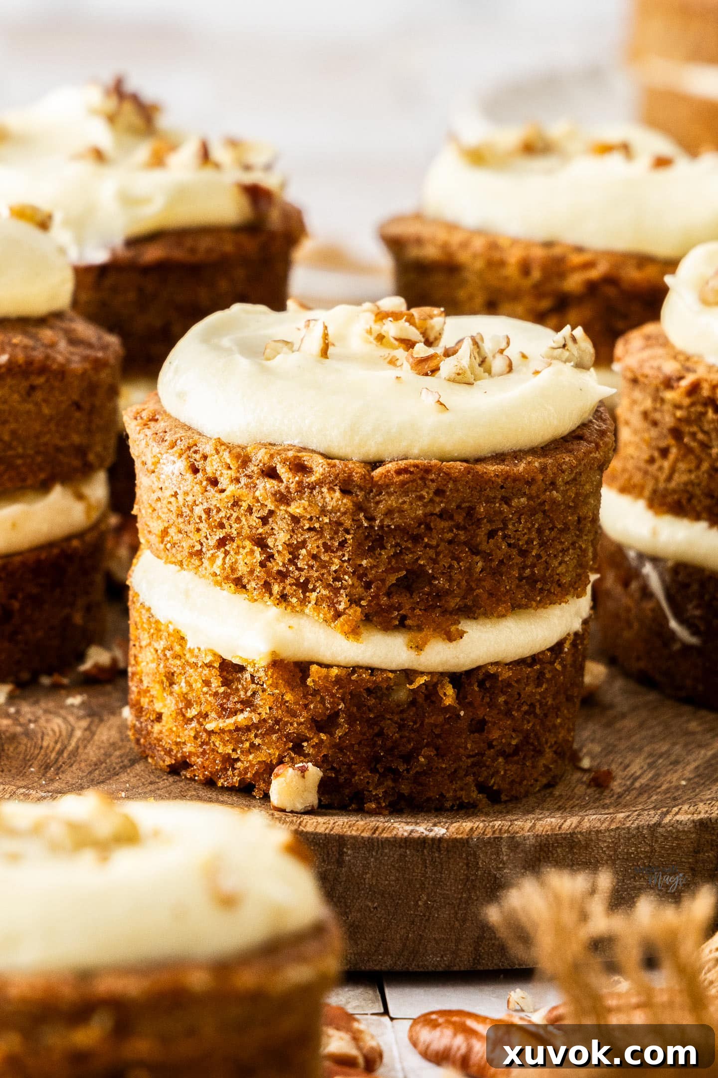 A close-up view of a single, perfectly assembled mini carrot layer cake, showing the moist layers and rich frosting.