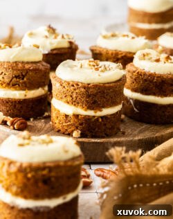 A batch of mini carrot cakes on a wooden platter, beautifully arranged and ready to be served.