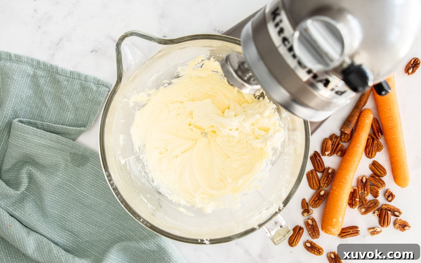 Softened butter and cream cheese perfectly beaten together in a mixer, forming a smooth, creamy base for frosting.