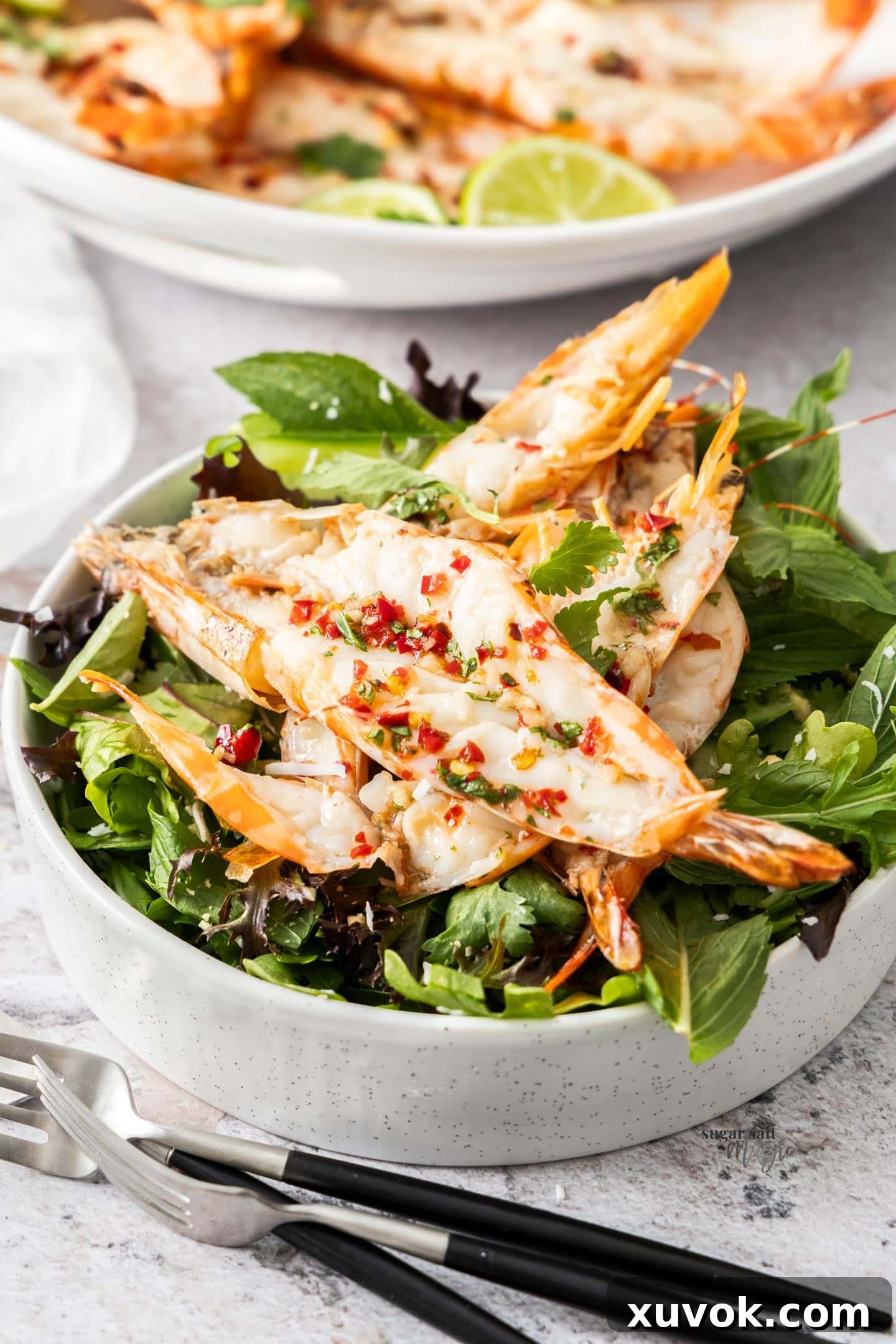 Butterflied prawns beautifully arranged on top of a fresh salad.