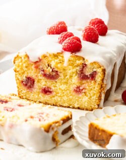 Closeup of the inside texture of the raspberry lemon loaf, showing the moist crumb and evenly distributed raspberries.
