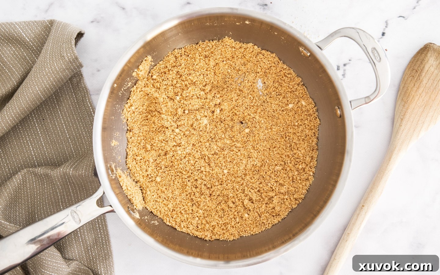 Ground almond meal toasting in a dry frying pan until golden brown and fragrant.