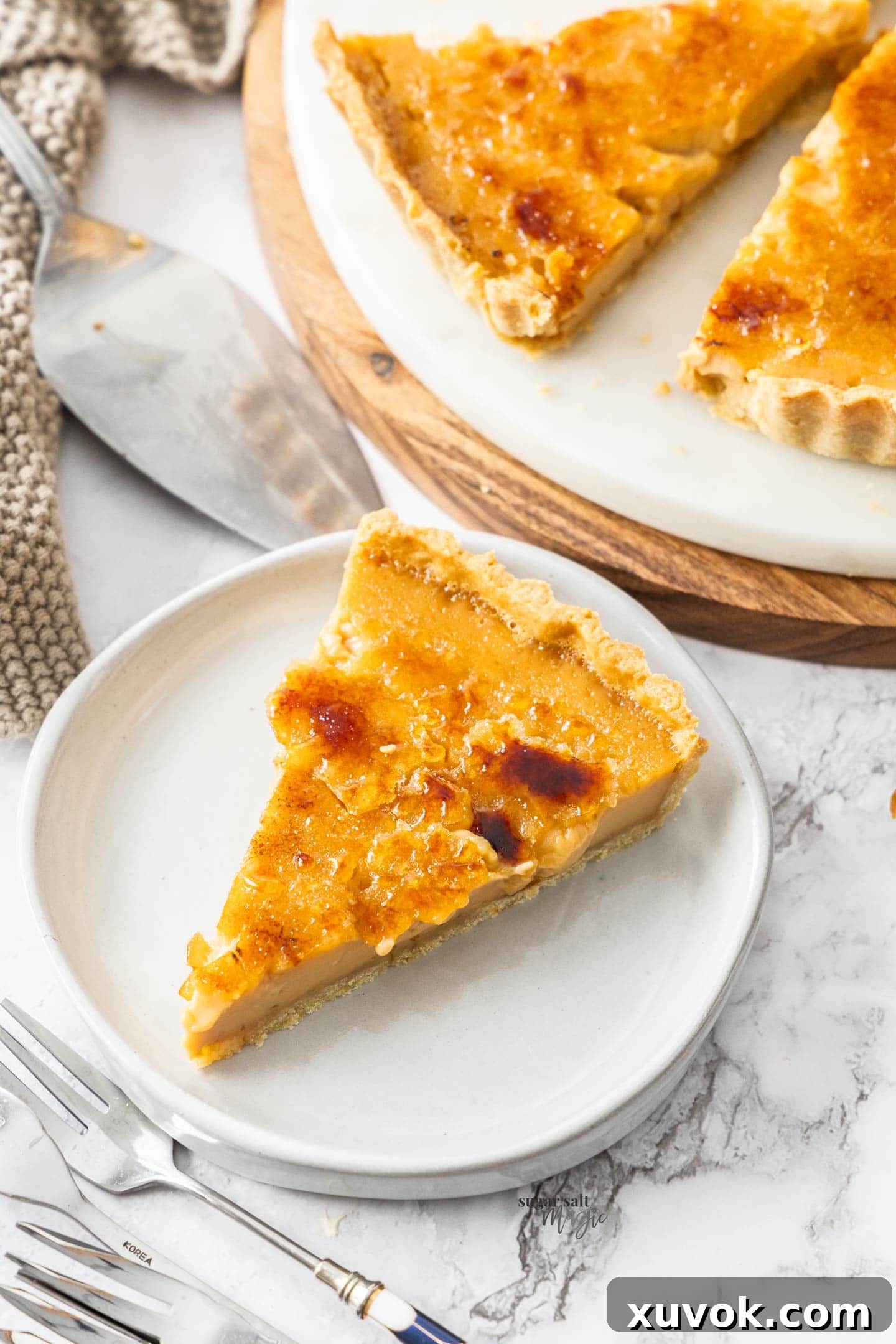 Top down view of a perfectly sliced caramel creme brulee tart, revealing the creamy caramel custard and flaky crust.