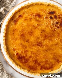 Top down view of the caramel creme brulee tart, showcasing its golden crackable top and inviting texture.