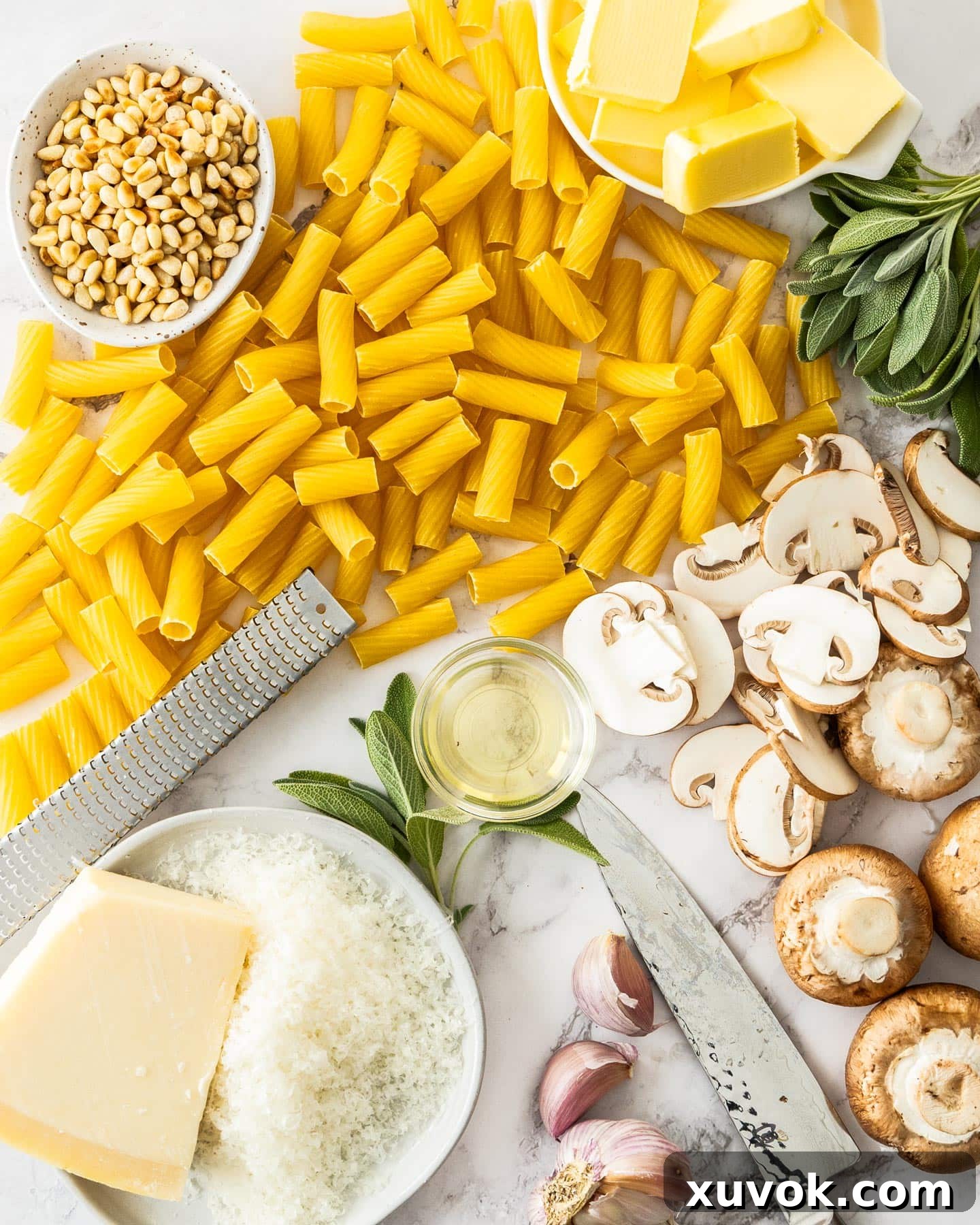 A vibrant display of fresh ingredients for sage butter pasta, including pasta, mushrooms, butter, garlic, sage, and pine nuts, arranged artfully on a wooden board.