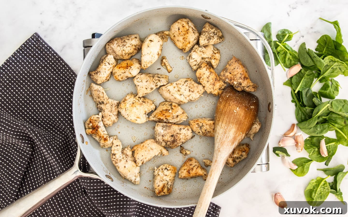 The chicken being cooked in a pan.