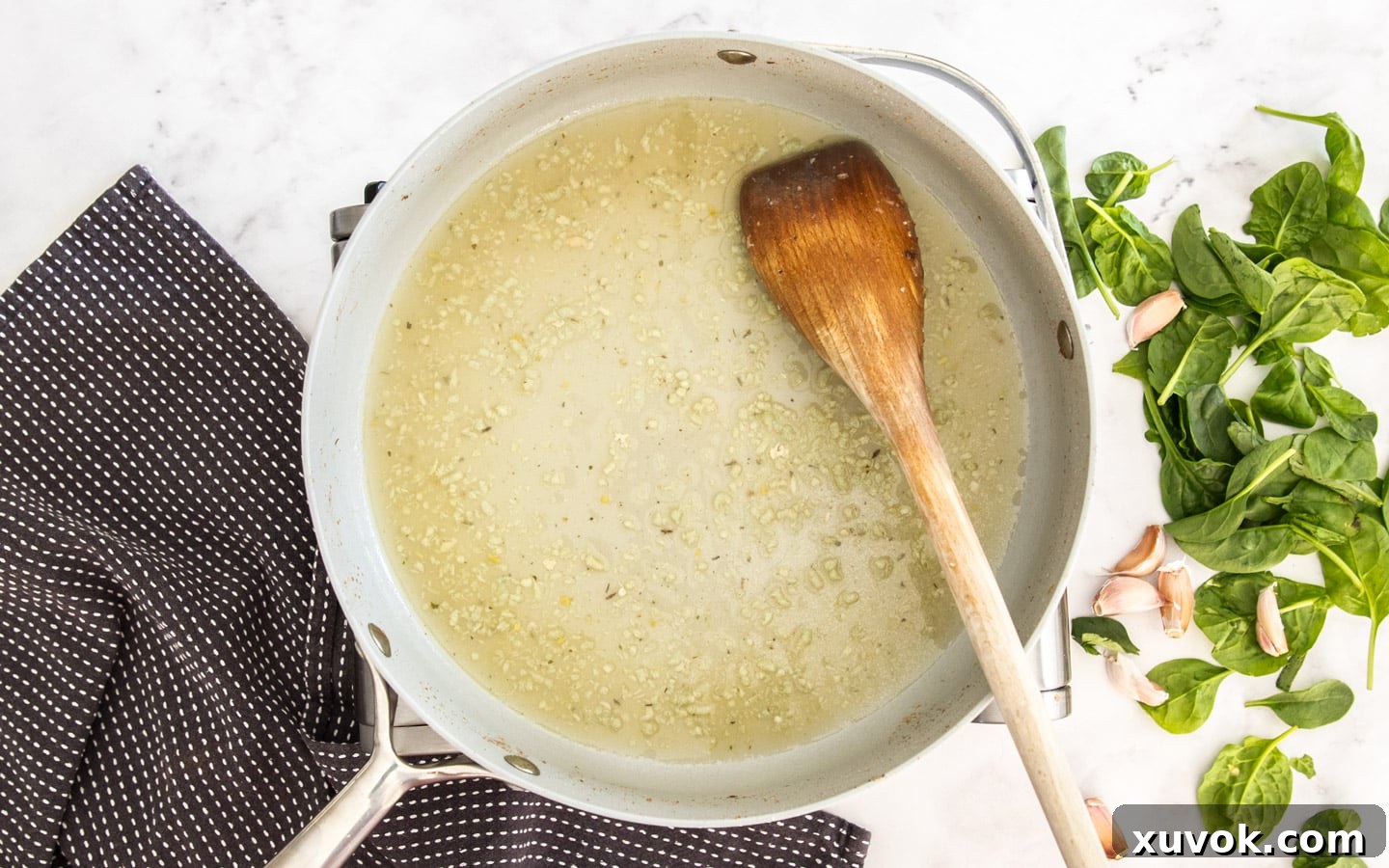 The garlic and stock in the pan being reduced.