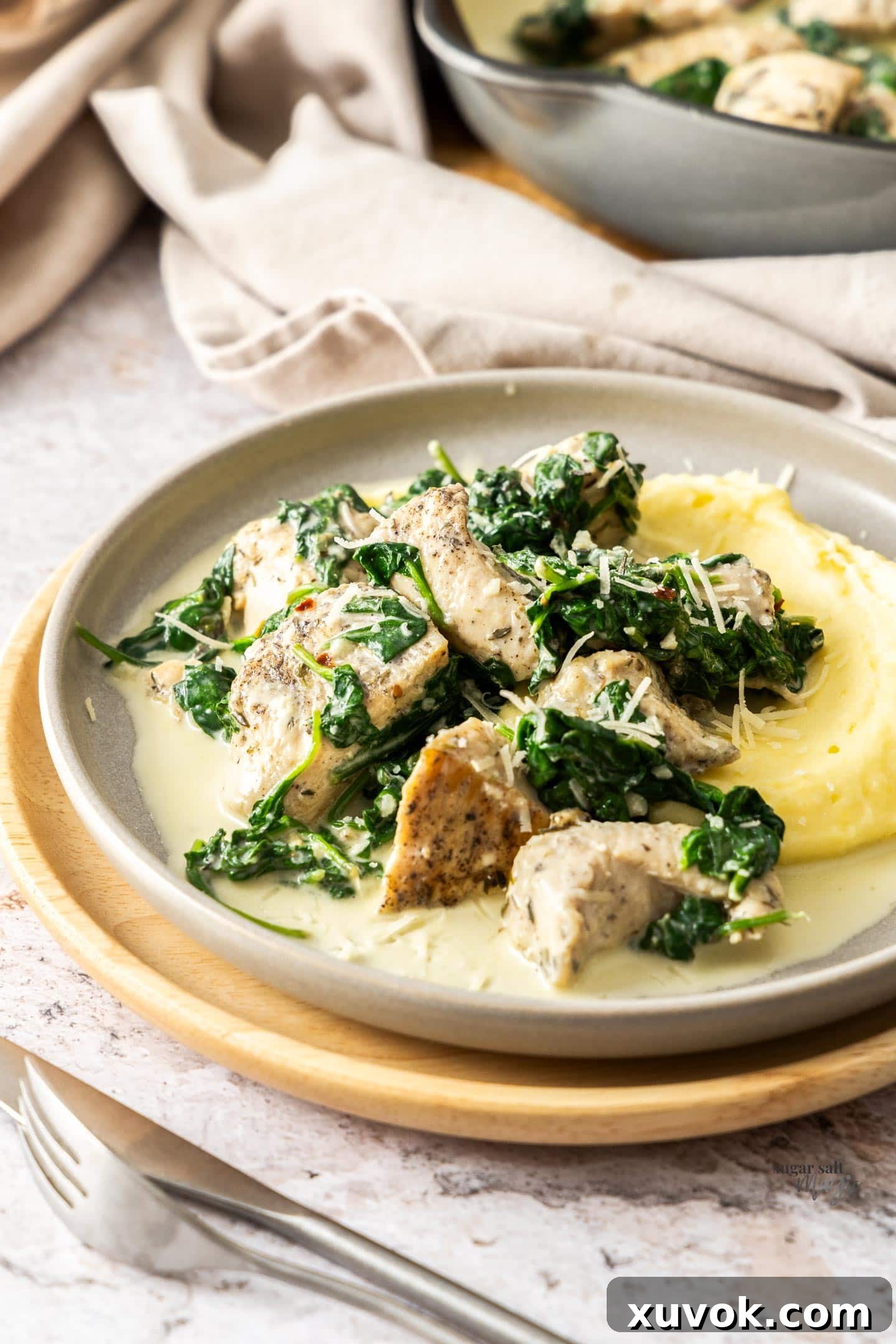 Creamy garlic chicken on a plate on a bed of mashed potato.