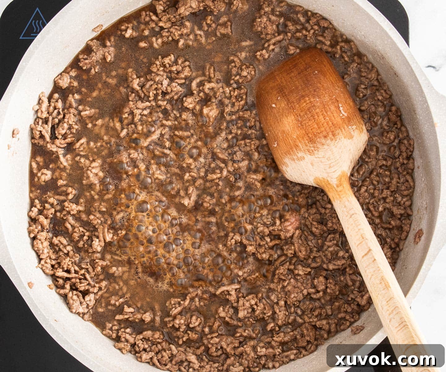 The sauce and beef bubbling in a pan.
