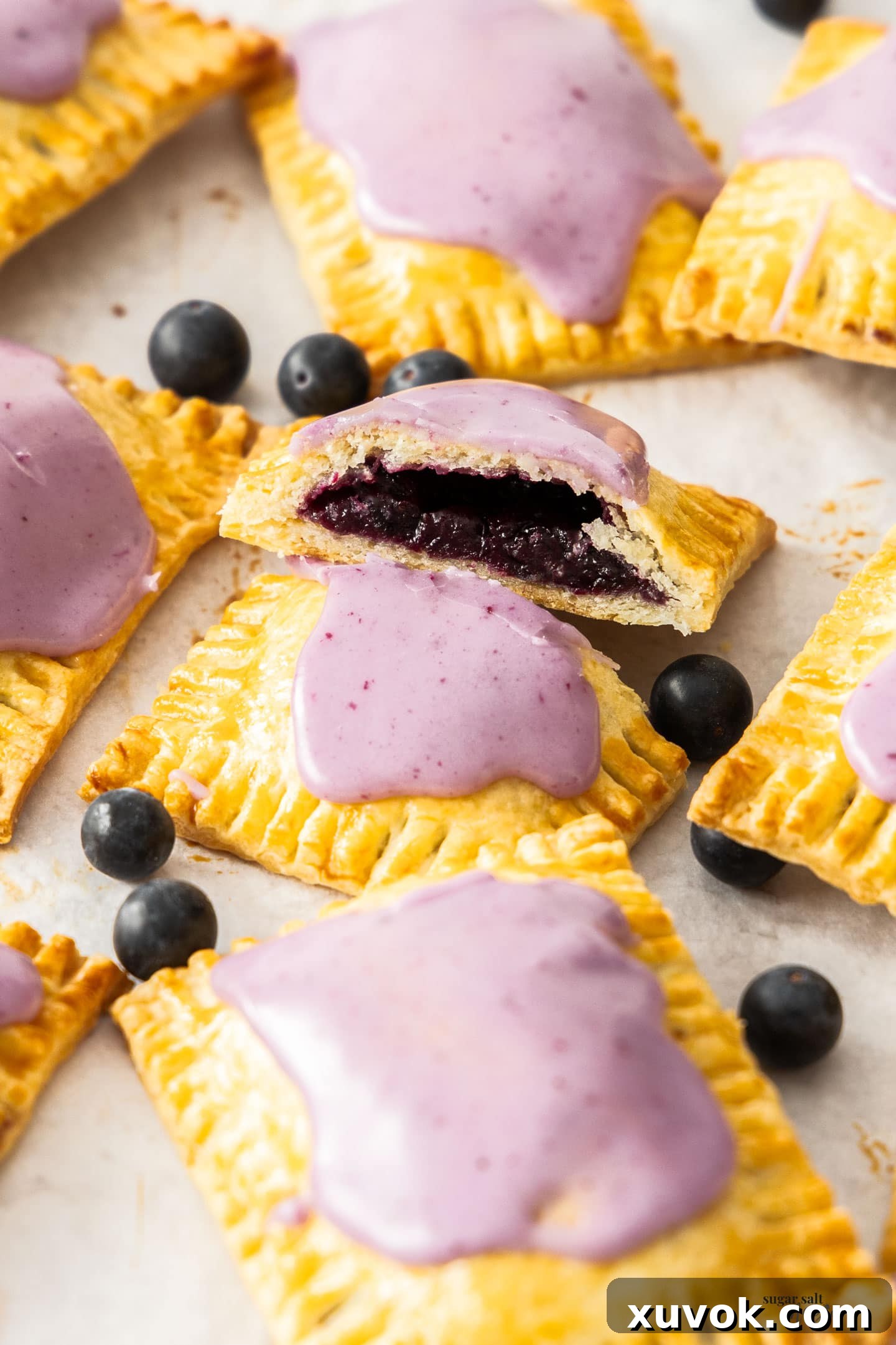 Closeup of a freshly baked homemade blueberry pop tart, cut open to reveal the vibrant jammy blueberry filling.