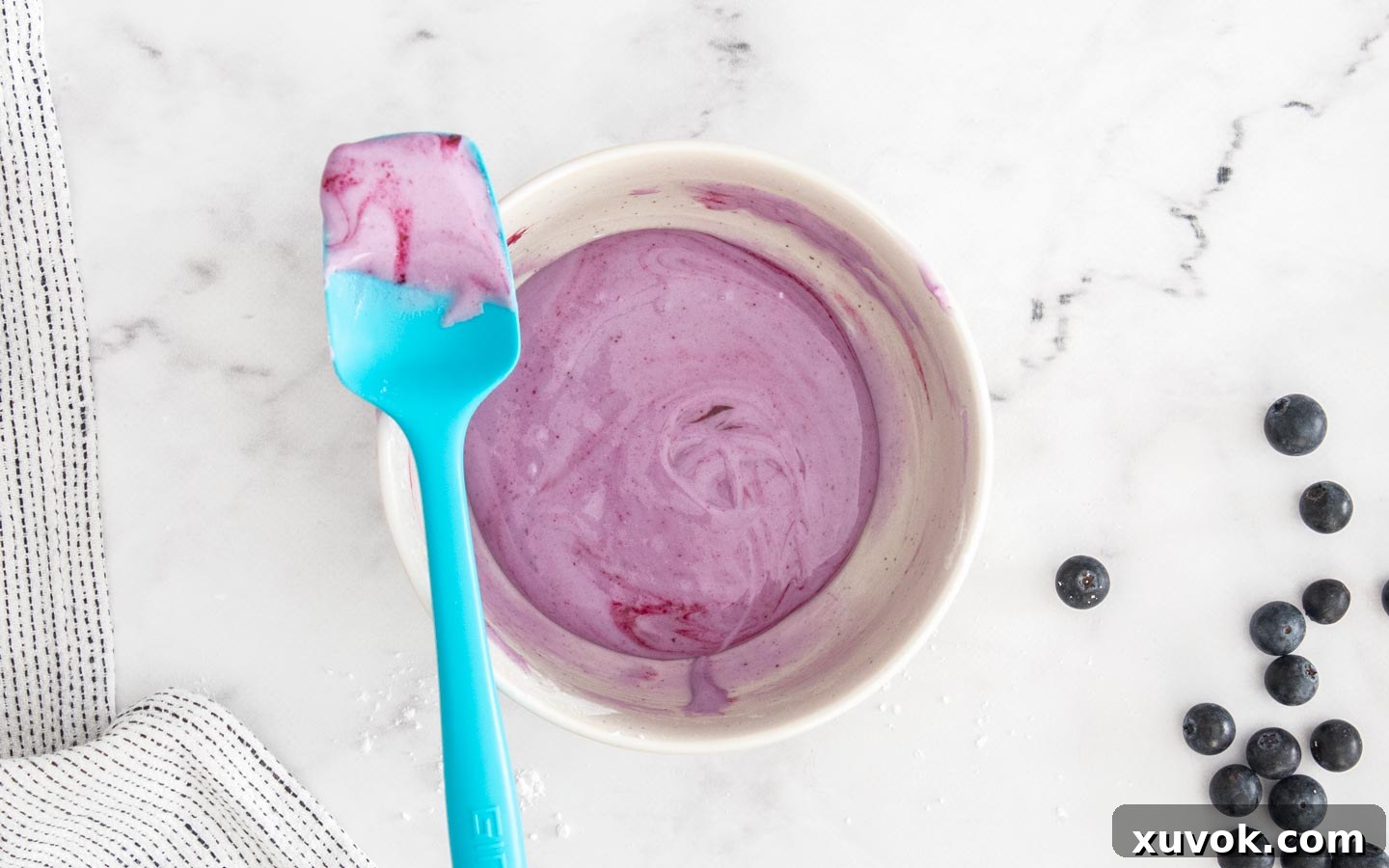 A bowl of creamy blueberry icing, perfectly mixed and ready to be spread onto the pop tarts.