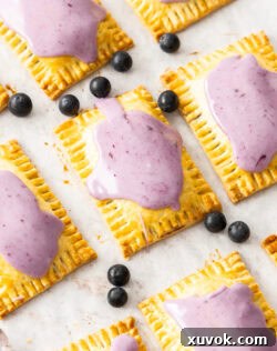 Top down view of blueberry pop tarts surrounded by fresh blueberries.