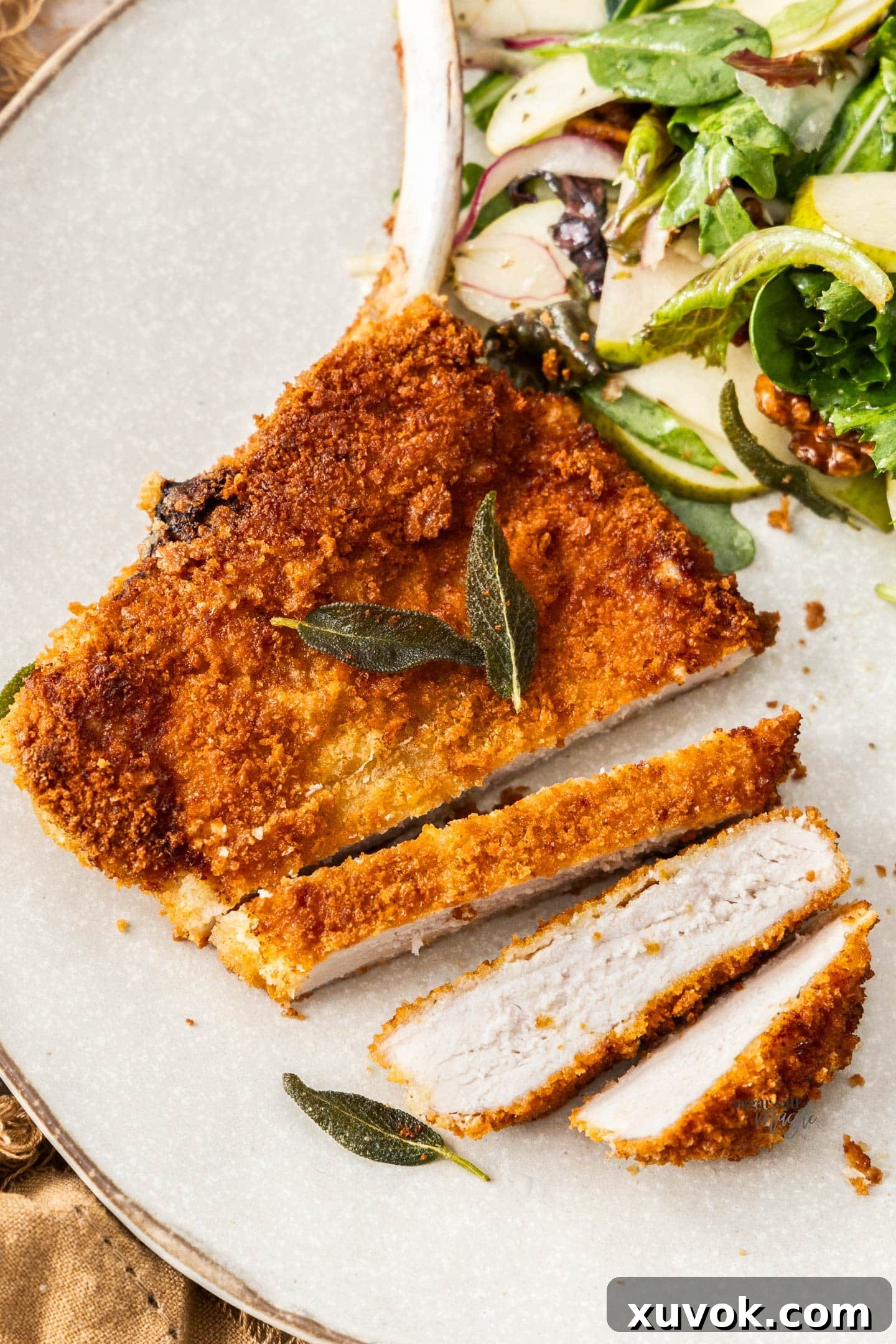 A top-down view of a pork cotoletta Milanese, expertly cut into thick slices, revealing the juicy interior and crunchy breading.