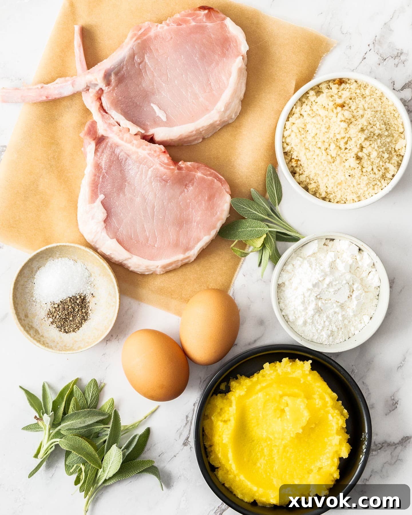 All the fresh ingredients laid out for making pork cotoletta Milanese, including cutlets, flour, eggs, breadcrumbs, and clarified butter.