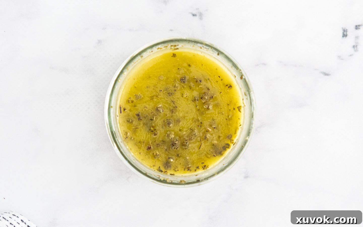 Top down view of homemade Italian dressing in a jar, ready for use.