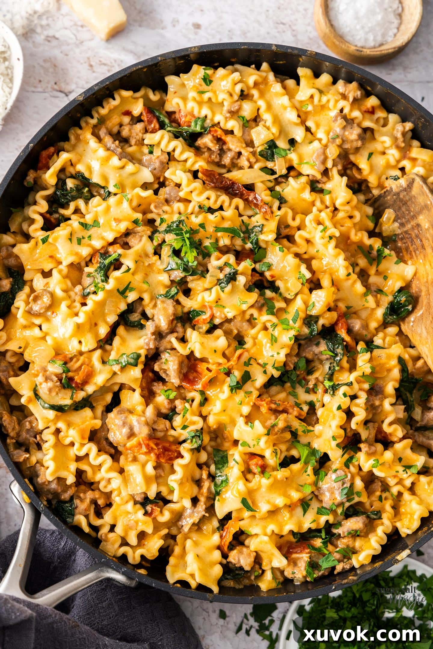 Top down view of a pan full of fennel sausage pasta, garnished with fresh parsley.