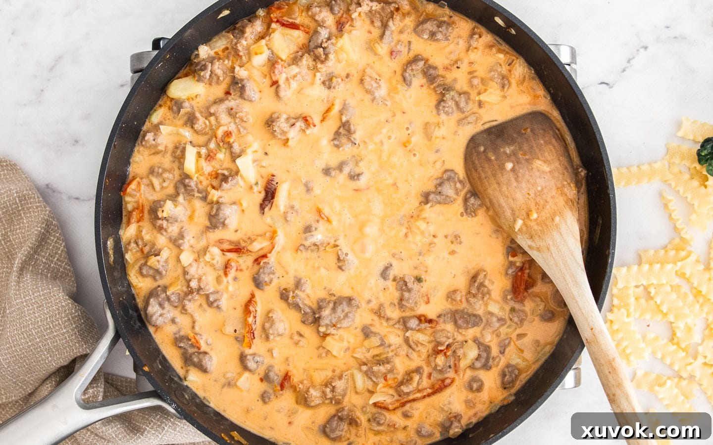 The pan with the creamy tomato sauce after cream has been added, showing a smooth, rich consistency.