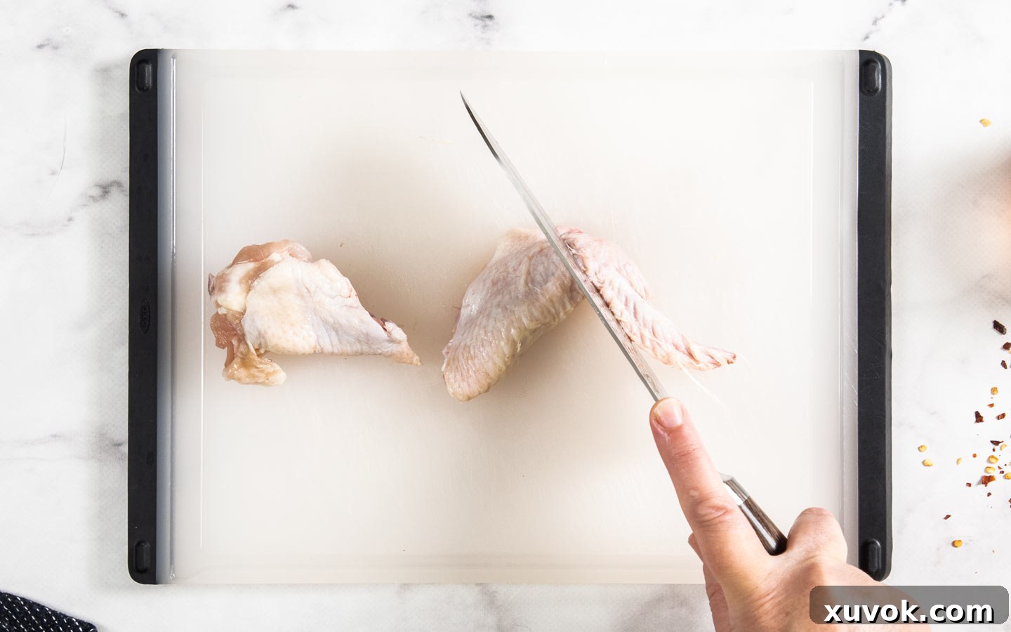A knife cutting a wing into segments at the joint.