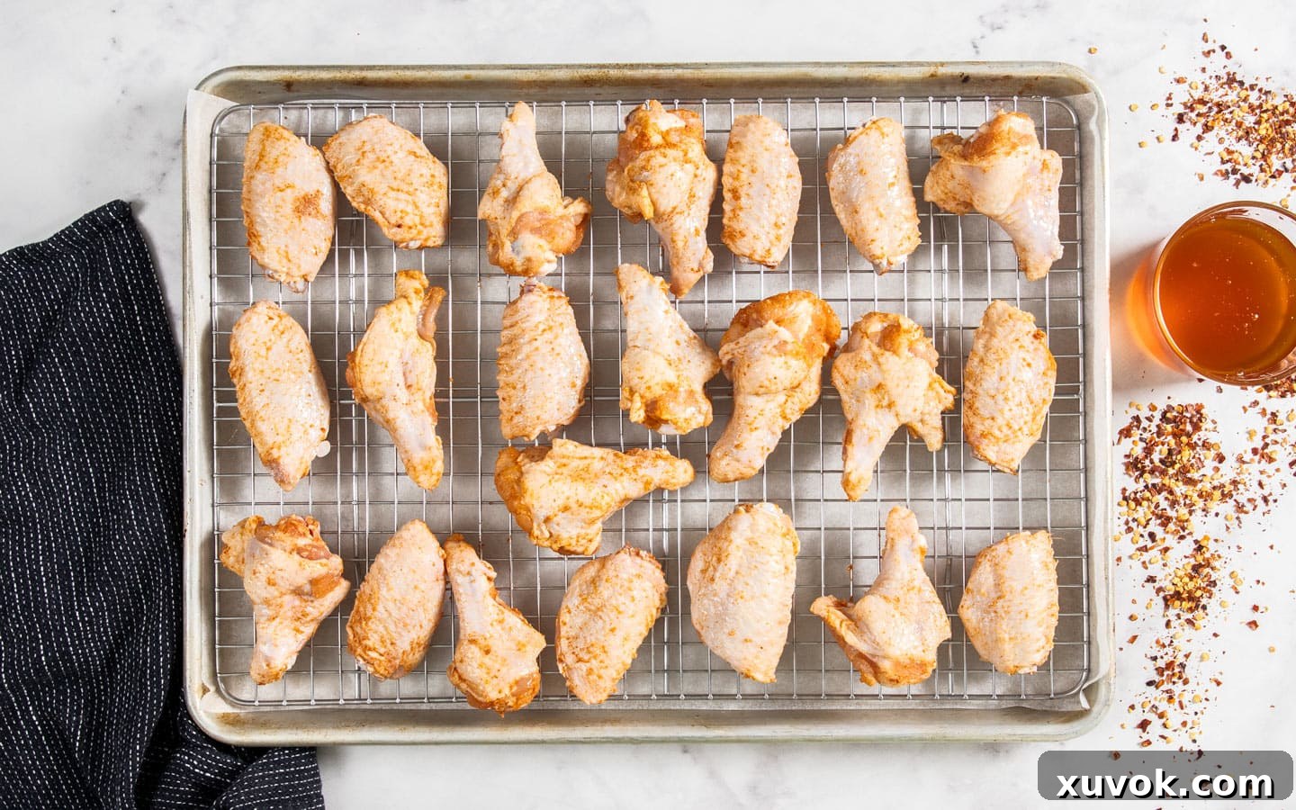 The seasoned wing pieces on a baking tray.