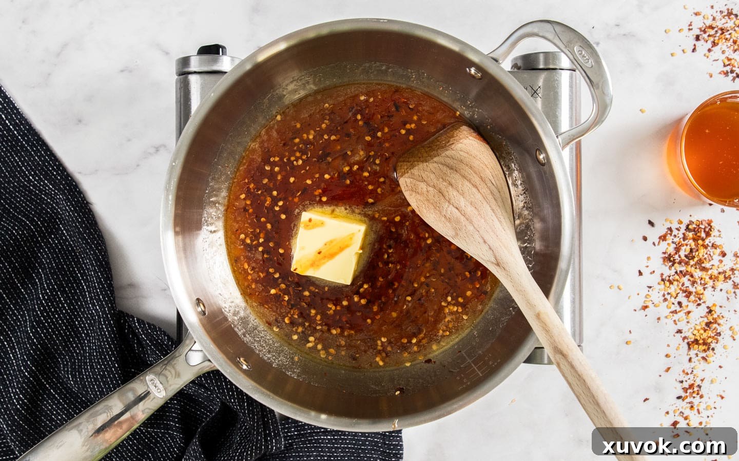 Honey and chilli with a large cube of butter in a saucepan.