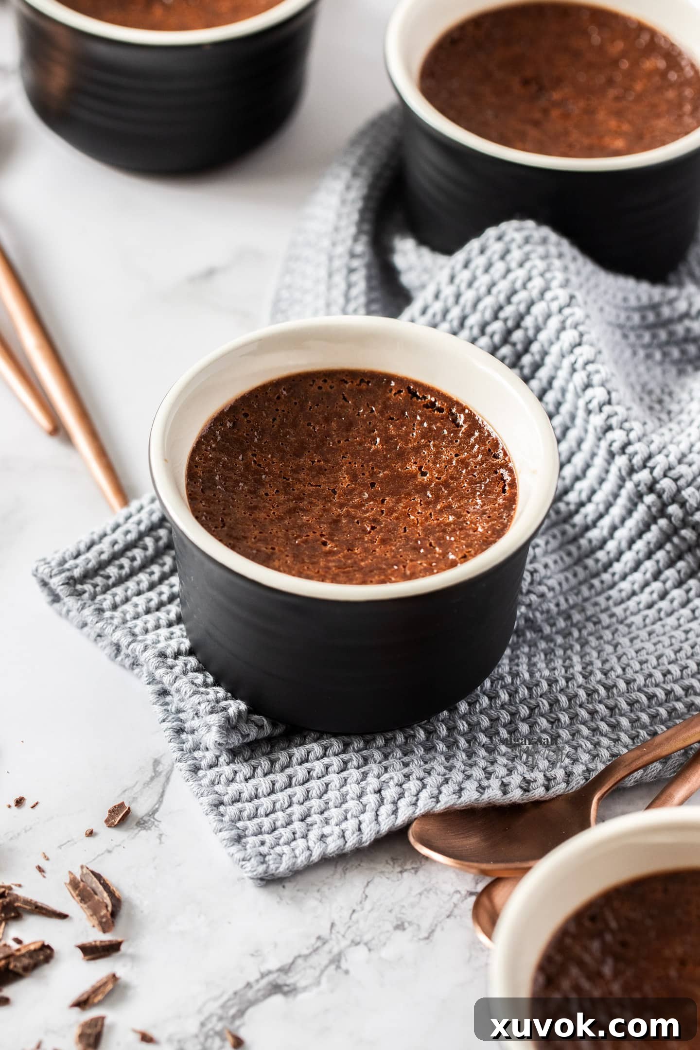 A smooth, dark chocolate crème brûlée in a ramekin, ready for the sugar topping and torching.