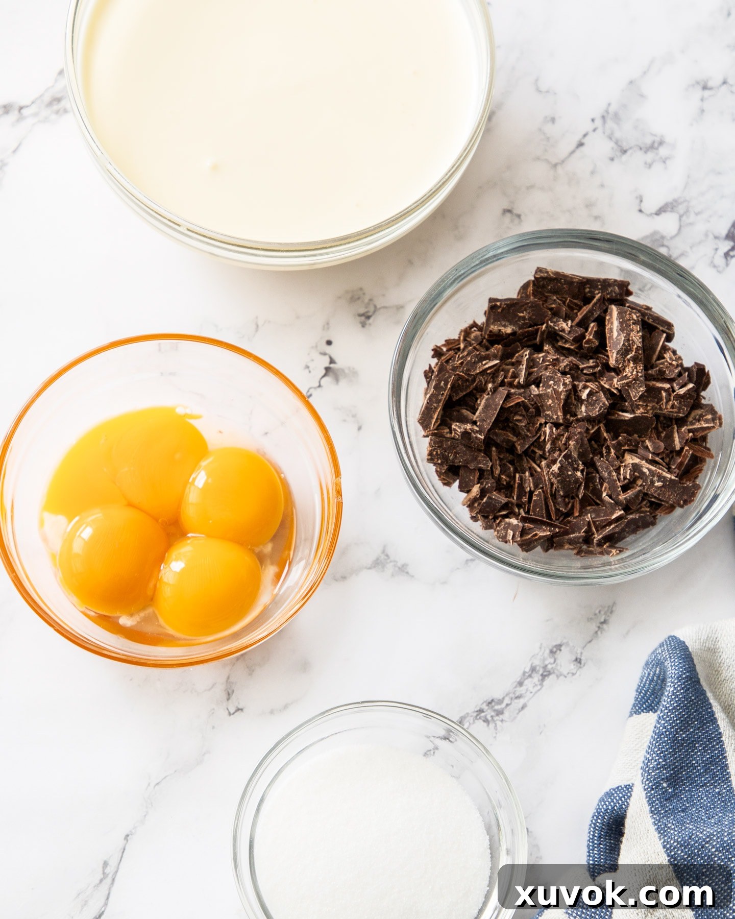 Four simple ingredients for making homemade chocolate crème brûlée: heavy cream, dark chocolate, egg yolks, and superfine sugar.