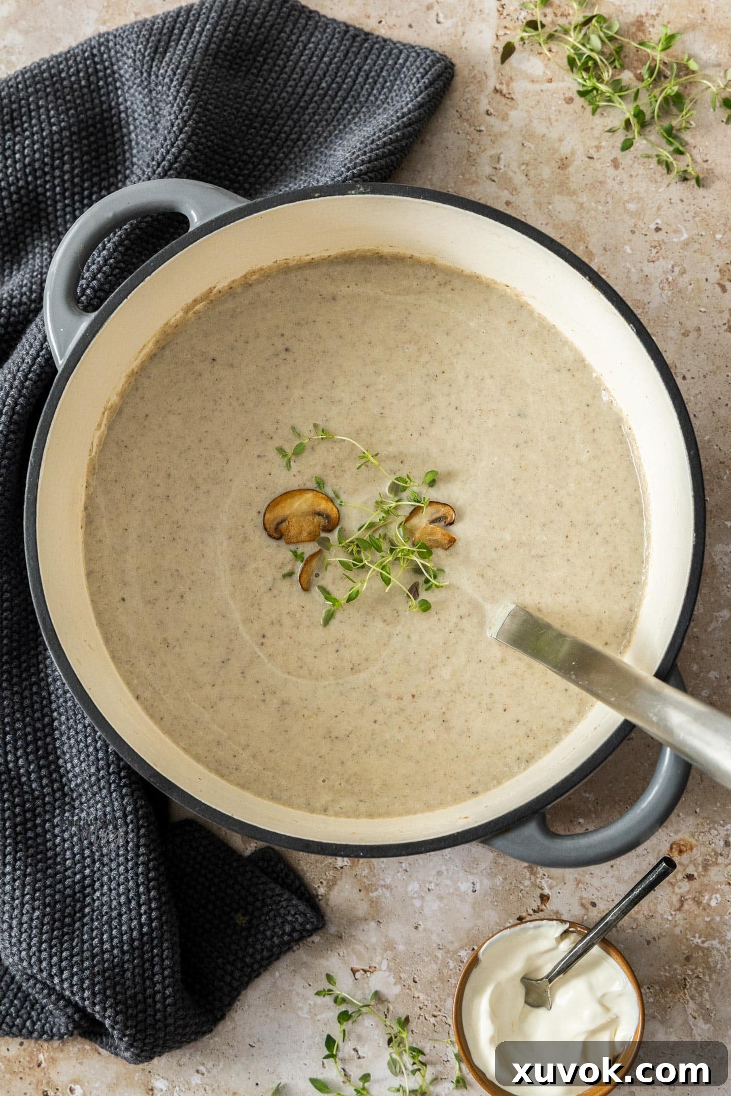 The finished creamy mushroom cauliflower soup in a large Dutch oven with a ladle, ready to be served.