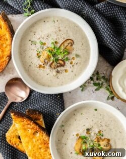 Top down view of two bowls of mushroom cauliflower soup.