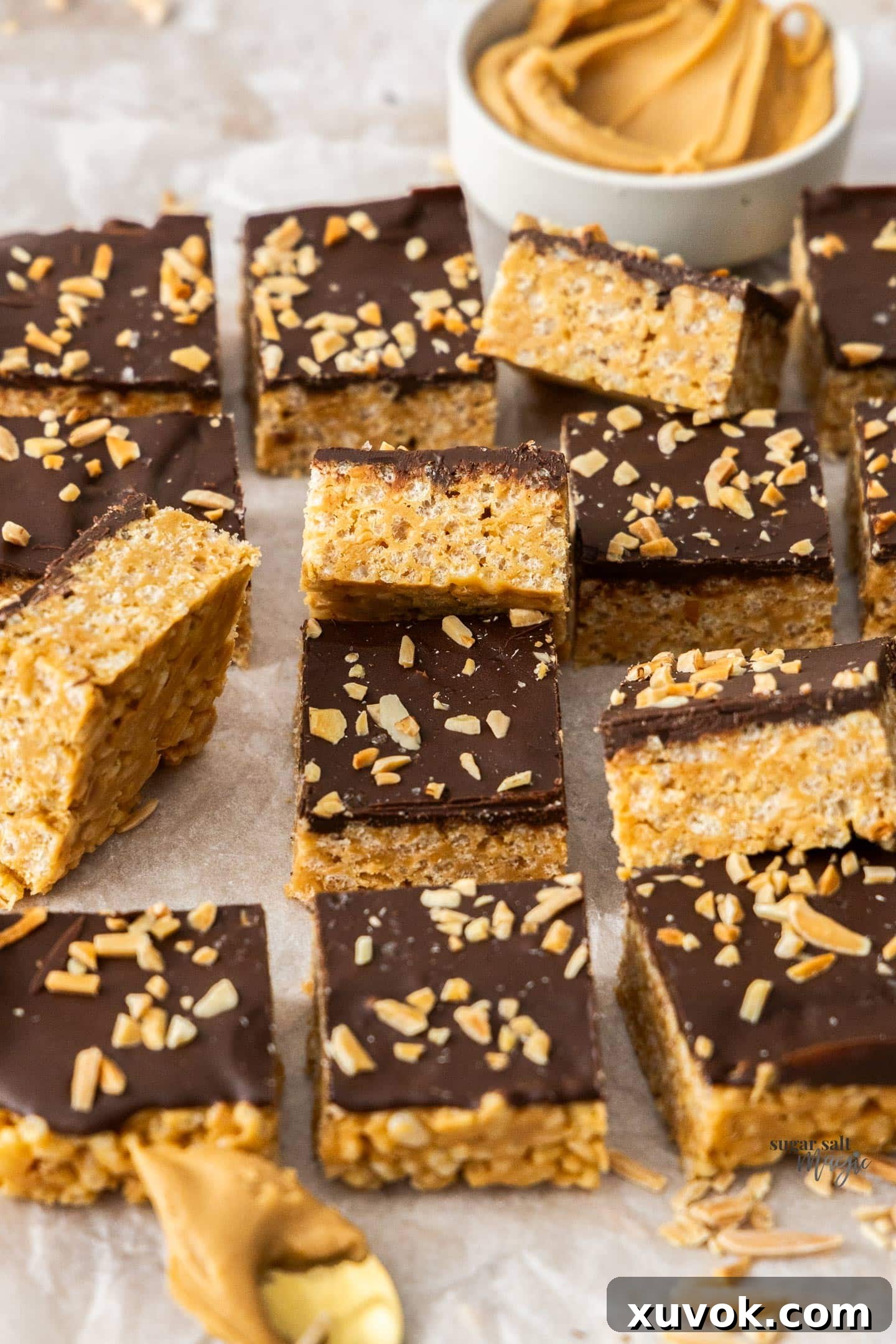 A batch of peanut butter rice crispy bars cut into squares, showcasing their layers of crispy peanut butter base and smooth chocolate topping.