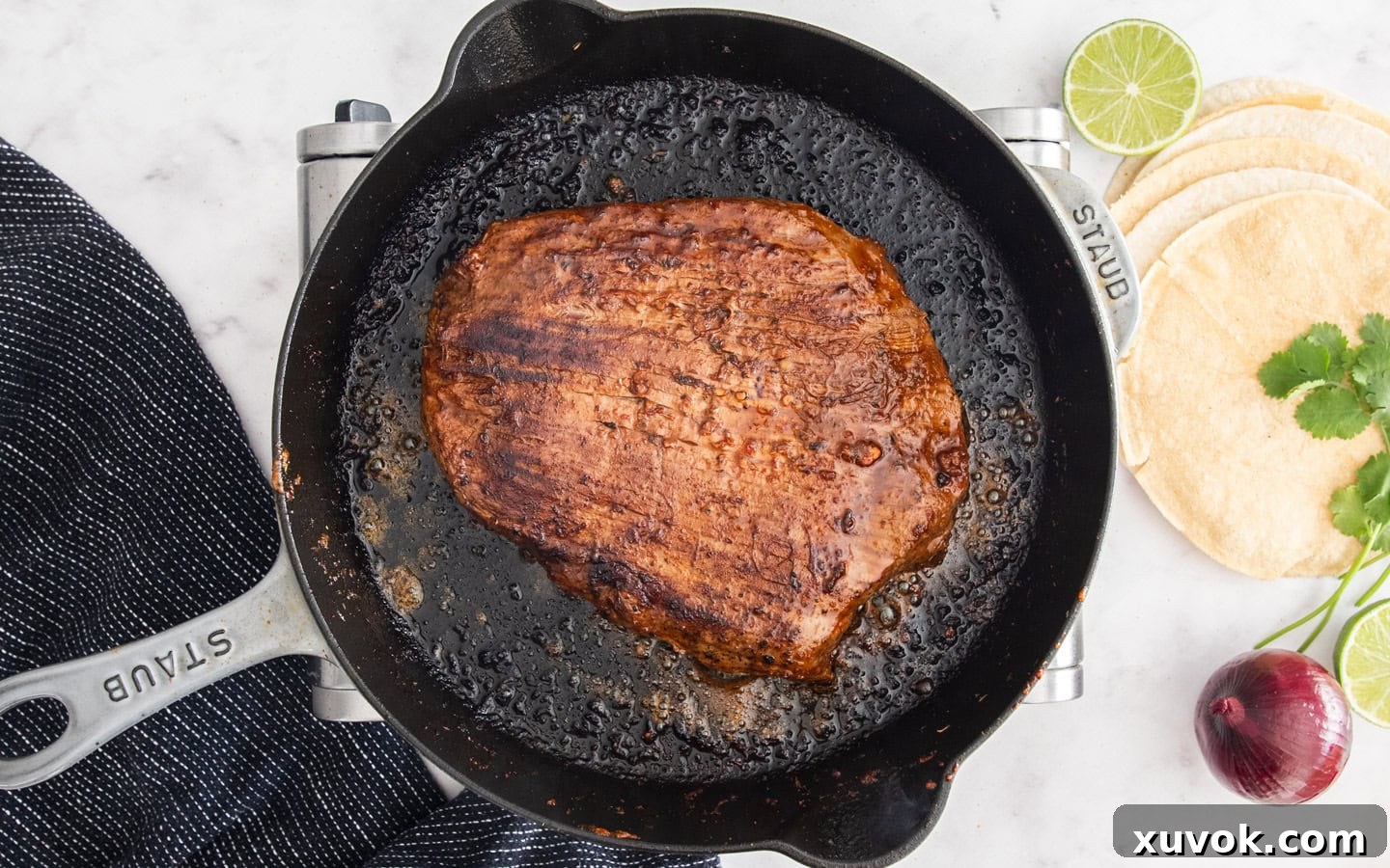 The cooked chipotle flank steak in a skillet.
