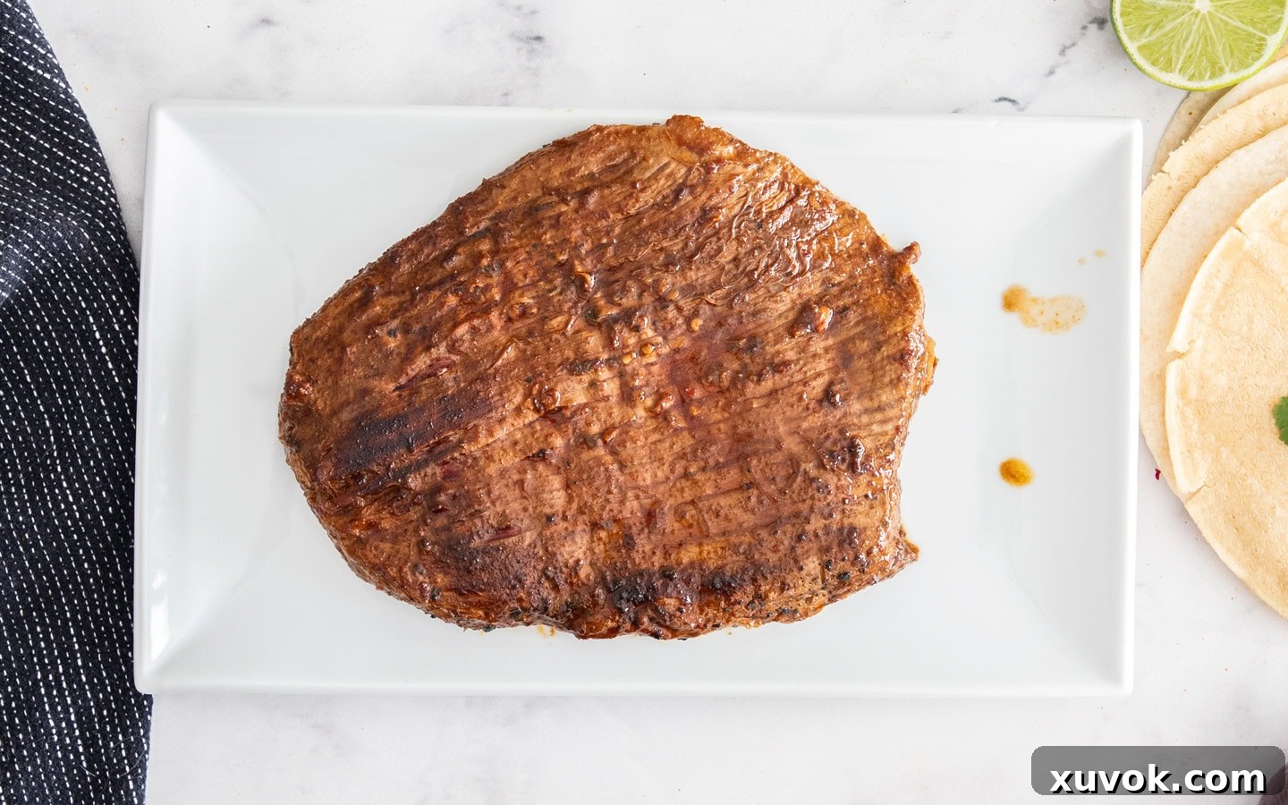 The cooked flank steak resting on a plate.